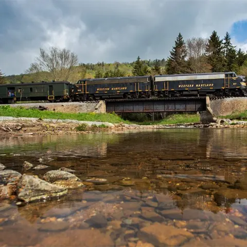 a train traveling down train tracks next to a body of water