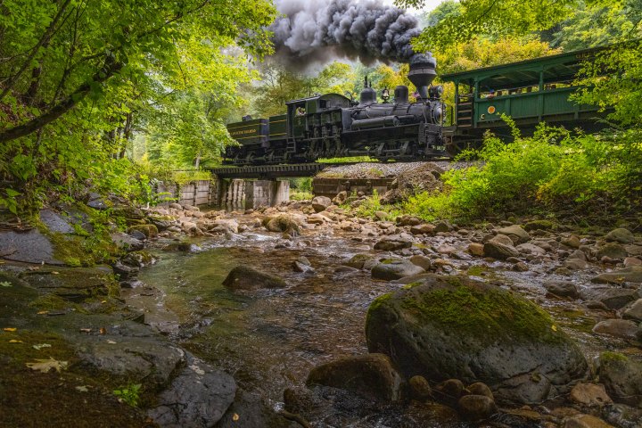 a train traveling down train tracks next to a river