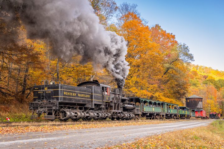 a steam train on a track with smoke coming out of it