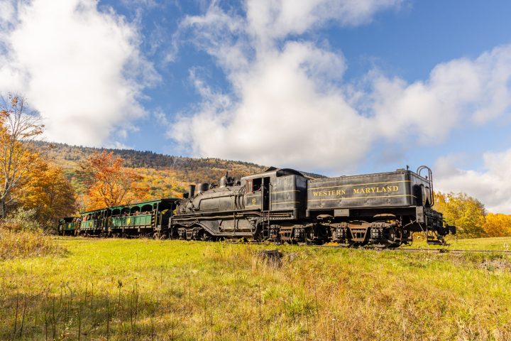 a train traveling down train tracks near a field