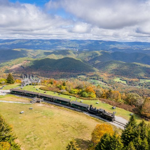 a train on a track with a mountain in the background