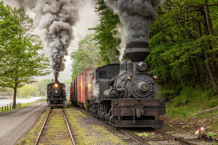 a steam engine on a train track with smoke coming out of it