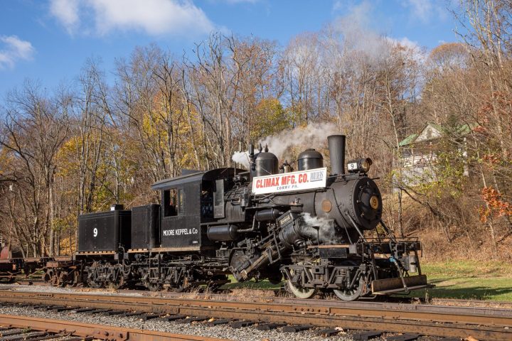 a train traveling down train tracks near a forest