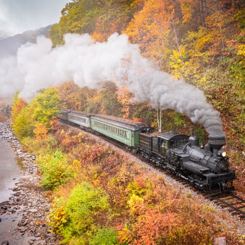 a steam train on a track with smoke coming out of it