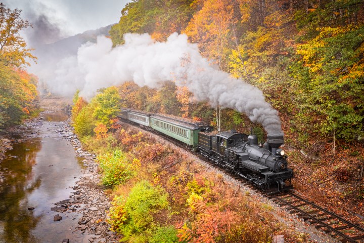 a steam train on a track with smoke coming out of it