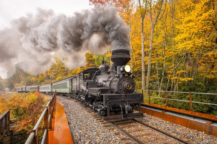 a steam train on a track with smoke coming out of it