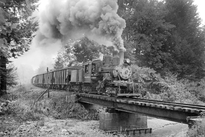 a steam train on a track with smoke coming out of it