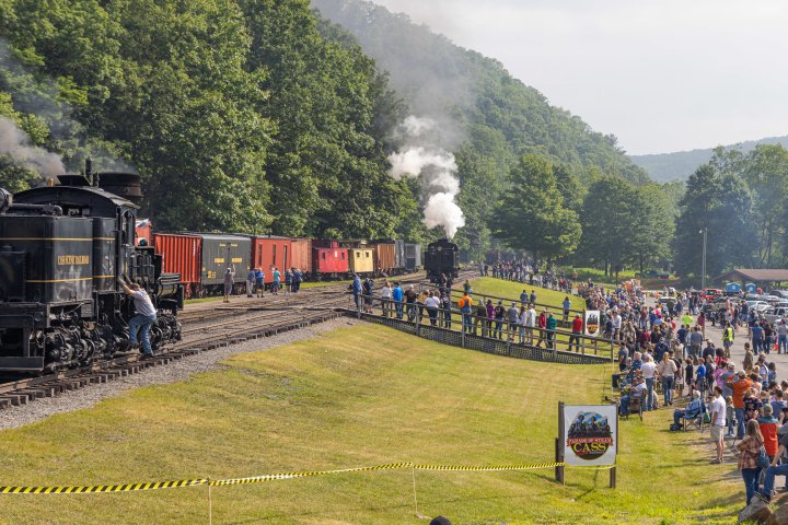 a group of people on a train track with trees in the background