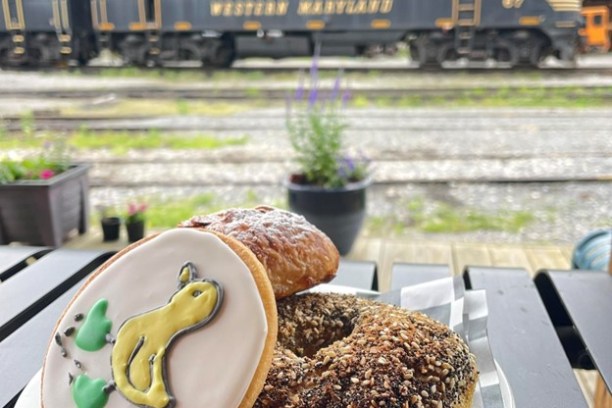 Three pastries on a plate with a vintage train in the background.